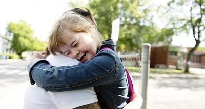 special needs girl hugging someone